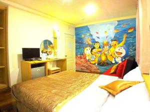 馬公市的住宿－情定海豚灣民宿，卧室配有一张大床,墙上挂有绘画作品
