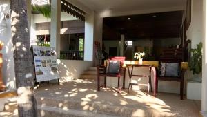 un tavolo e delle sedie seduti all'esterno di un edificio di Golden Pine Beach Resort a Pran Buri