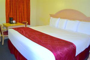 a bedroom with a large bed with a red and white blanket at Passport Inn Niagara Falls in Niagara Falls