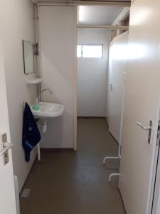 a small bathroom with a sink and a mirror at B&B boerderij rust, in pipowagens! in Den Helder +33 photos