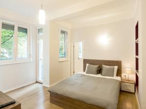 - une chambre blanche avec un lit et 2 fenêtres dans l'établissement Solunska Apartment, à Sofia