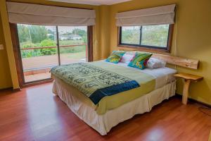 a bedroom with a bed and a large window at Hotel Uka Mana in Hanga Roa
