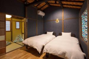 two beds in a room with a christmas tree at Yoshimigura Machiya House in Kyoto