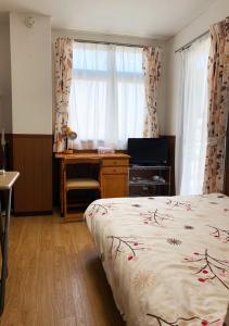 Schlafzimmer mit einem Bett, einem Schreibtisch und einem Fenster in der Unterkunft Gojyo Ivy in Kyoto