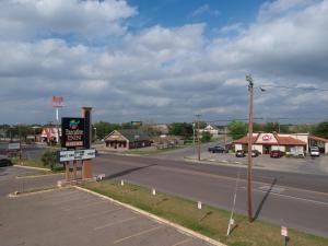 an empty street with a gas station on the side of a road at Executive Inn in Beeville