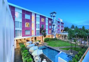 a view of a hotel with a pool and umbrellas at favehotel Cimanuk Garut in Garut
