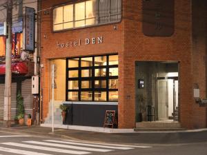 un bâtiment avec un den d'hôtel dans une rue de la ville dans l'établissement hostel DEN, à Tokyo