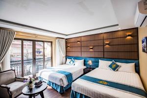 une chambre d'hôtel avec deux lits et un canapé dans l'établissement Mimosa Hotel Sapa, à Sa Pa
