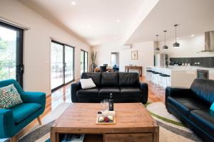 a living room with black furniture and a table at Golton in the Gap in Halls Gap