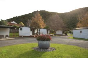 a group of cottages with a flower pot in the grass at Parklands Marina Holiday Park in Picton