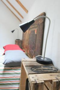 une lampe assise sur une table en bois à côté d'un lit dans l'établissement grande Cahute, à Soultzmatt