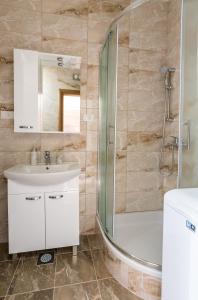 uma casa de banho com um lavatório e um chuveiro em Apartment Batinica em Sibenik