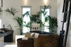 ミコノス・シティにあるエルメス ミコノス ホテルのバスルーム(植物のあるバスタブ付)