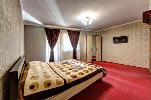 a bedroom with a large bed and a red carpet at Villa Vlad & Spa in Bukovel