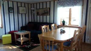 Kilsborgs Gård - Lakehouse في Svanskog: غرفة معيشة مع طاولة وأريكة