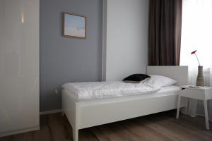 Un dormitorio con una cama blanca con una foto en la pared en Aparthotel TU-TU en Essen