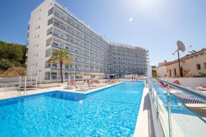 un hotel con piscina frente a un edificio en Pierre&Vacances Mallorca Deya, en Santa Ponsa