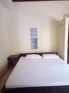 a bedroom with a white bed and a window at Mimba Private House in Padangbai