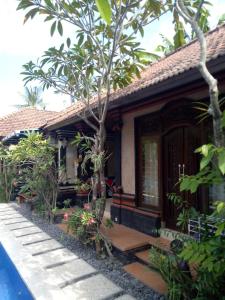 a small house with a porch and a tree at Mimba Private House in Padangbai