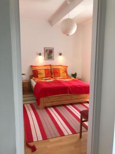 ザラカロシュにあるElvira Apartmanのベッドルーム1室(赤い掛け布団付きのベッド1台付)