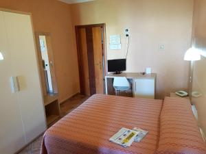 a bedroom with a bed and a desk with a computer at Hotel Francesco in Padenghe sul Garda