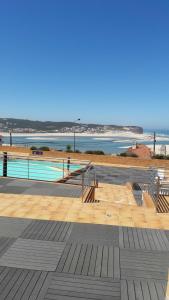 a swimming pool with a view of the ocean at Pé na Praia da Foz in Foz do Arelho