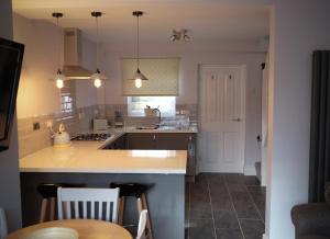 a kitchen with a counter and a sink and a table at Conwy Cottage in Conwy