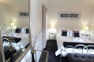 a bedroom with two beds and a mirror at Coromandel Apartments in Coromandel Town