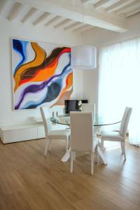 a dining room with a painting on the wall at Appartamenti San Pietro in Perugia