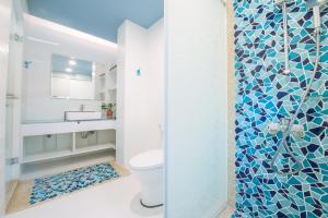 Sapphire Inn في ماغونغ: حمام مع دش مع مرحاض ومغسلة