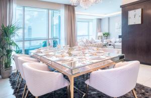 a dining room with a glass table and chairs at Elite Royal Apartment - Burj Residences Tower 5 in Dubai