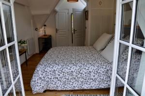 Schlafzimmer mit einem Bett mit einer schwarzen und weißen Bettdecke in der Unterkunft L ' Authentique in Pernes-lès-Boulogne