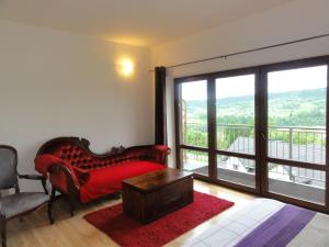 a living room with a red couch and a large window at Wilkowka in Wołkowyja