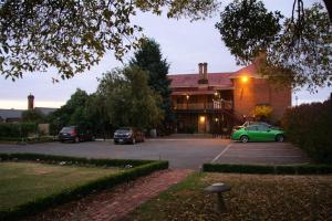 a green car parked in a parking lot in front of a building at Central Springs Inn in Daylesford +29 photos