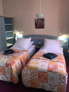 duas camas sentadas uma ao lado da outra num quarto em Hôtel du Commerce em Les Sables-dʼOlonne