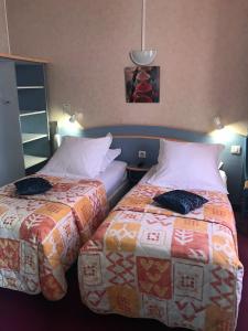 two beds sitting next to each other in a room at Hôtel du Commerce in Les Sables-d'Olonne