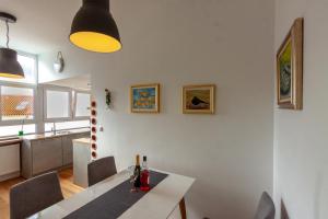 a kitchen and dining room with a white table and chairs at Apartman Colosseum in Pula