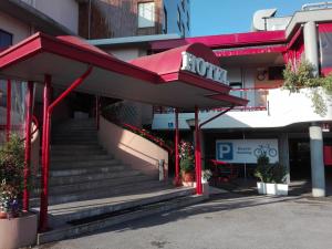 a building with a red awning and stairs in front at Hotel Internazionale in Cervignano del Friuli