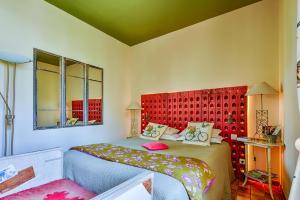 - une chambre avec un lit et une tête de lit rouge dans l'établissement La Prévôté - Hôtel Particulier & Restaurant, à LʼIsle-sur-la-Sorgue
