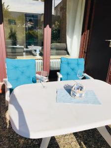 a white table with two wine glasses and a basket on it at Küstenbude Glück in Grömitz