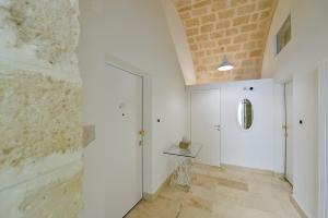 un corridoio con pareti bianche e un muro di mattoni di Le Stanze di Filippo Tandoi a Corato