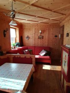 a living room with red couches and a table at Appartamento Gliera in Arabba