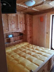 Cette chambre comprend un grand lit et des placards en bois. dans l'établissement Appartamento Gliera, à Arabba