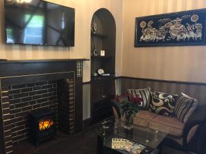 a living room with a couch and a fireplace at Greyfriars Lodge Canterbury in Canterbury