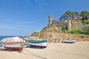 three boats on the beach with a castle in the background at Apartment Tossa in Tossa de Mar