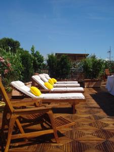 una fila di sedie a sdraio su una terrazza di legno di Hotel Miramare a Forte dei Marmi