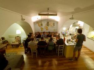 people are gathered around a dining room table at Balkan Soul Hostel in Belgrade