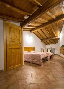 Un dormitorio con una cama grande en una habitación con techos de madera. en L'Angoletto dei Calanchi, en San Michele in Teverina