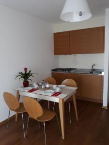 a kitchen with a white table and chairs and a kitchen at Lacroma Bio Hotel & Apartments in Grado