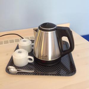 a tea kettle and cups on a tray on a table at Hotel Nostos in Frikes